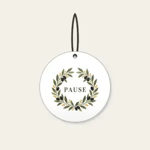 Olive Branch Wreath with PAUSE Ceramic Ornament in white: An olive branch wreath with dark fruits and ochre dots circles the word PAUSE in simple deep green serif letters.