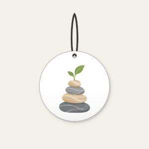 Cairn Stones with a Sprout Ceramic Ornament in white: Stacked cairn stones in grey and sand, topped with a tiny green sprout.