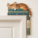 Corner Reading Cat Sign with a cat sleeping on a stack of three books in warm brown and teal, drawn to fit a corner