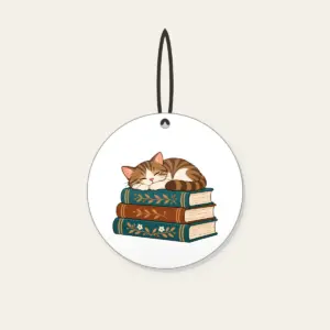 Cat Napping on Three Books Ceramic Ornament in white: A cat curled up asleep on a stack of three books, in warm brown and teal.