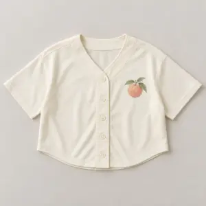 Peach Crest Cropped Baseball Jersey with small flat printed peach crest with two leaves at the left chest of a plain cream jersey