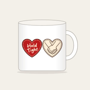 Hold Tight Heart and Hands Mug in white: A red dashed heart marked “Hold Tight” on one side and two clasped cream hands in brown on the other.
