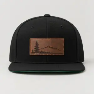 Engraved Pine Patch Snapback with engraved-style leather patch showing a pine tree and a ridge outline on the front panel