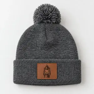 Lantern Patch Pom-Pom Beanie with an engraved camp lantern on the patch, single tone