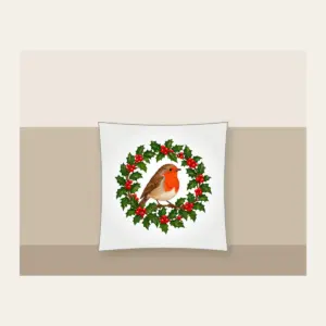 Robin in a Holly Wreath Pillow in white: A robin perches in a holly wreath in red, brown and green.