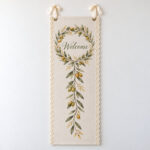 Olive Wreath Linen Lace Welcome Banner with an olive wreath in sage and gold around the word "Welcome" in the upper part of the long narrow banner with a slim olive sprig trailing below