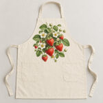 Berry Patch Kitchen Apron with centred bib print of a strawberry cluster with white blossoms and tiny leaves in red, green and cream