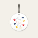 Paper Planes and Dotted Flight Paths Ceramic Ornament in white: Paper planes trace dotted flight paths across cream in navy, red and yellow.