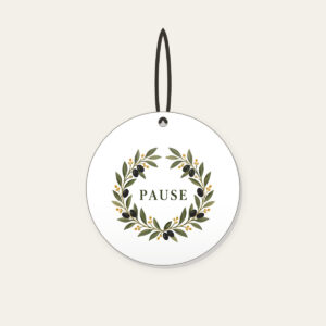 Olive Branch Wreath with PAUSE Ceramic Ornament in white: An olive branch wreath with dark fruits and ochre dots circles the word PAUSE in simple deep green serif letters.