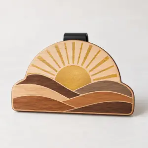 Wooden Sunrise Visor Clip with a half sun with rays and layered hills in wood tones with a printed gold sun