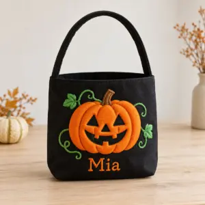 Black candy bag with embroidered puffed orange pumpkin and a name stitched below
