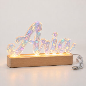 Star hologram acrylic letters spelling Aria on a wooden LED base