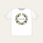 Olive Branch Wreath with PAUSE T-Shirt in white: An olive branch wreath with dark fruits and ochre dots circles the word PAUSE in simple deep green serif letters.