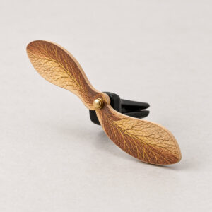 Maple Seed Spinner Wooden Car Clip with a winged maple seed charm in warm brown and gold on the clip