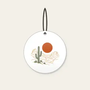 Desert Sun and Canyon Lines Ceramic Ornament in white: A rust-orange sun disc over sparse canyon contour lines and one sage cactus silhouette, flat screen look.