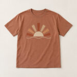 Clay Sunburst Heavyweight Tee with compact front chest panel print of a half sun with seven rust and sand rays and a thin wave line beneath