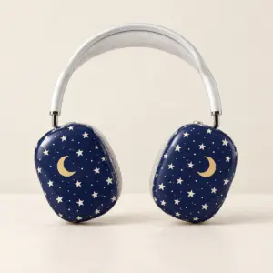Midnight-blue headphone earcup covers with cream stars and a crescent moon, shown on headphones as a display prop.