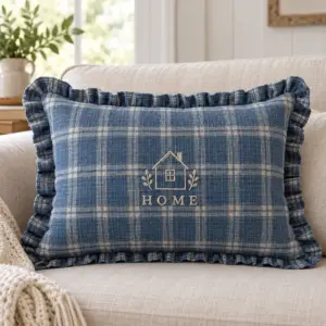 Blue plaid ruffled pillow embroidered with a small house and the word HOME