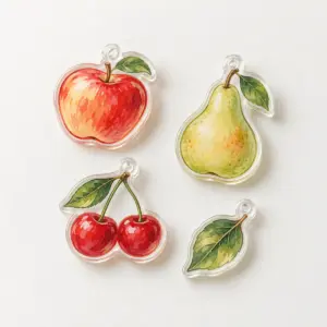 Orchard Fruit Acrylic Charm Set with separate acrylic charms printed in cherry red, pear green, apricot and cream, each with a small hole and simple outline