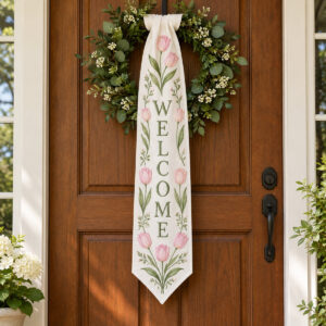 White lace linen sash embroidered with pink tulips and the word WELCOME in sage green