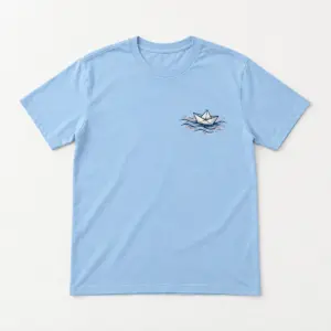 Paper Boat Harbor Tee with small chest print of a folded paper boat on ink-line waves in navy and coral