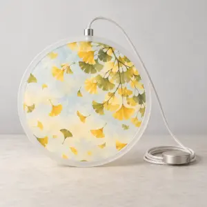 Ginkgo Glow Hanging Lamp with a round lamp face printed with falling ginkgo leaves in butter yellow and olive over a pale sky wash