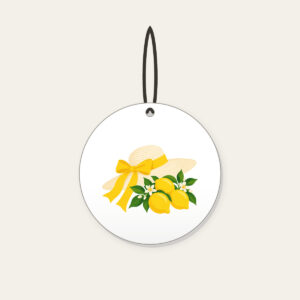 Sunhat with Three Lemons Ceramic Ornament in white: A wide sunhat with a ribbon beside three lemons in cream, lemon yellow and green.