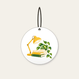 Lamplit Desk with Books and Fern Ceramic Ornament in white: A warm yellow desk lamp glows beside a stack of books and a potted plant in cream and green.