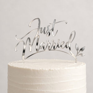 Silver Mirror Cake Topper with a silver mirrored acrylic topper with the exact text "Just Married" in a flowing cut-out script, 8in class, with a small pair of leaves at one end