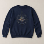 Navy Compass Rose Crew Sweatshirt with compact front chest panel print of a compass rose made of tiny stars and thin lines in ivory and gold, the letter N at the top, no other text