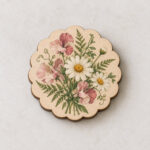 Pressed Posy Layered Wood Magnet with top layer with a flat printed illustration of a daisy, sweet pea and fern posy in dusty pink, yellow and green over a pale wood base layer