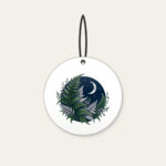 Moonlit Fern Fronds on Navy Ceramic Ornament in white: Silver and deep green fern fronds curl over navy beneath a small crescent moon.
