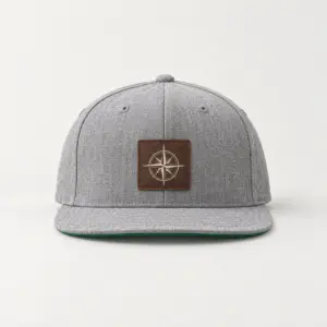Compass Patch Snapback with a compass rose in cream line art printed with DTF on a small rectangular rustic dark brown faux leather patch