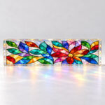 A freestanding rectangular hologram acrylic plaque with a flat jewel-toned botanical mosaic print.