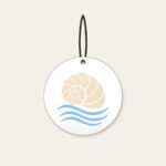 Cream Spiral Shell Over Blue Currents Ceramic Ornament in white: A cream spiral shell above three pale-blue flowing current lines.
