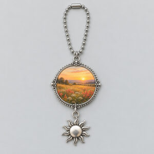 Round metal meadow-print photo charm with a dangling sun and bead chain