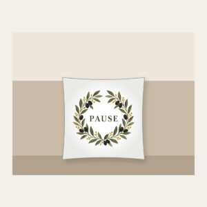 Olive Branch Wreath with PAUSE Pillow in white: An olive branch wreath with dark fruits and ochre dots circles the word PAUSE in simple deep green serif letters.