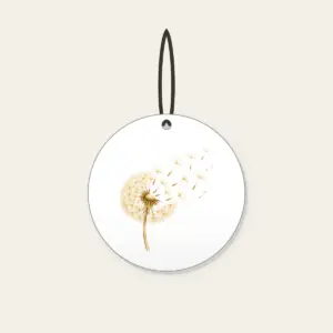 Dandelion Seeds Drifting Away Ceramic Ornament in white: A dandelion seed head with its seeds drifting away in cream and pale gold.