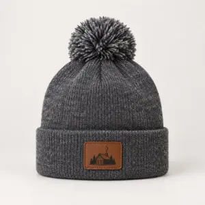 Cabin Patch Pom-Pom Beanie with small flat printed patch design on the cuff showing a cabin outline with a curl of chimney smoke