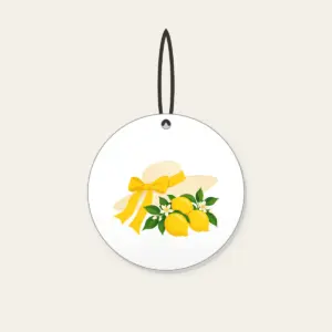 Sunhat with Three Lemons Ceramic Ornament in white: A wide sunhat with a ribbon beside three lemons in cream, lemon yellow and green.