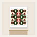 Cabin, Tree and Star Patchwork Canvas Print in white: Patchwork squares hold simple cabin, tree and star motifs in red, cream and green.