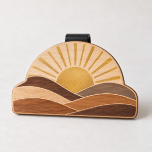 Wooden Sunrise Visor Clip with a half sun with rays and layered hills in wood tones with a printed gold sun