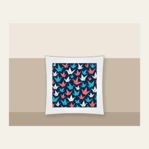 Origami Cranes on Navy Pillow in white: Folded paper cranes in coral, teal and cream scatter across a navy ground.
