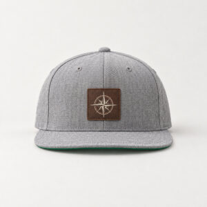 Compass Patch Snapback with a compass rose in cream line art printed with DTF on a small rectangular rustic dark brown faux leather patch